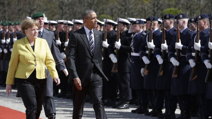 Acompanhado da chanceler alemã, Angela Merkel, Presidente Obama passa em revista guarda de honra