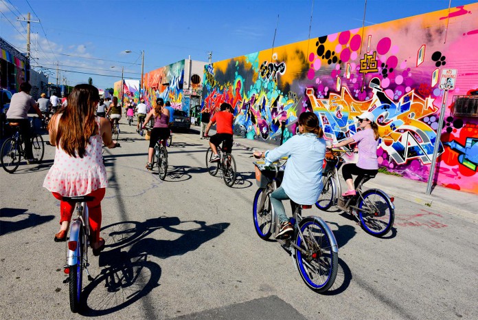 Ciclistas passam pelo bairro de Wynwood, em Miami, rumo ao museu PAMM, na regiao Downtown da cidade