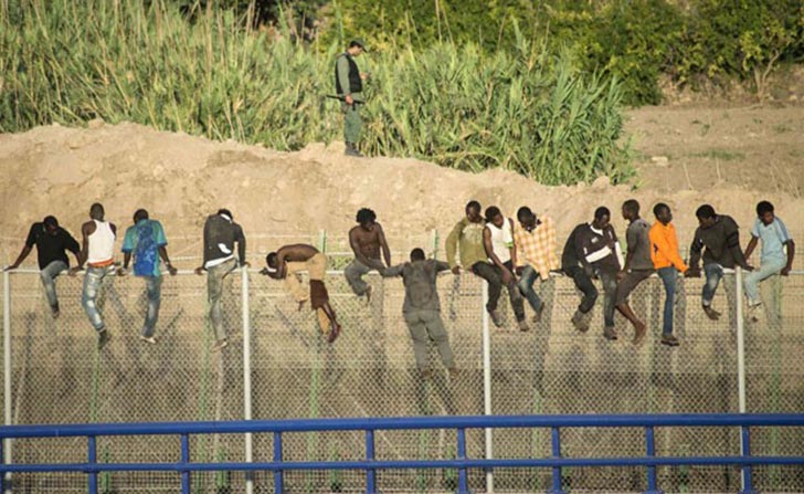 Imigranetes africanos pulam a cerca na fronteira com a Espanha