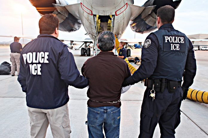 Polícia de imigração leva até o avião homem para ser deportado