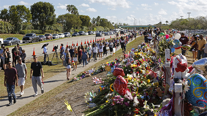 Pais e alunos caminham próximo ao memorial para as vítimas do massacre na Marjory Stoneman Douglas High School (Foto: David Santiago/Miami Herald/TNS/Getty Images)