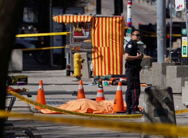 Policial é visto ao lado de uma vítima no local do atropelamento FOTO Carlo Allegri Reuters