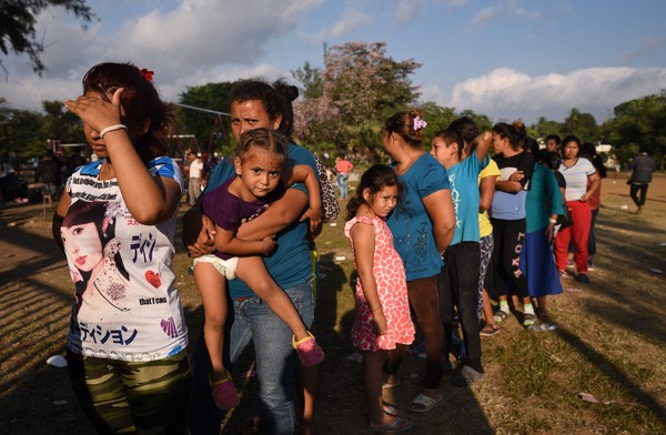 Imigrantes da América Central que participam da caravana em direção aos Estados Unidos fazem fila por comida em um campo de esportes em Matias Romero, Estado de Oaxaca, México. (Foto AFP Victoria Razo)