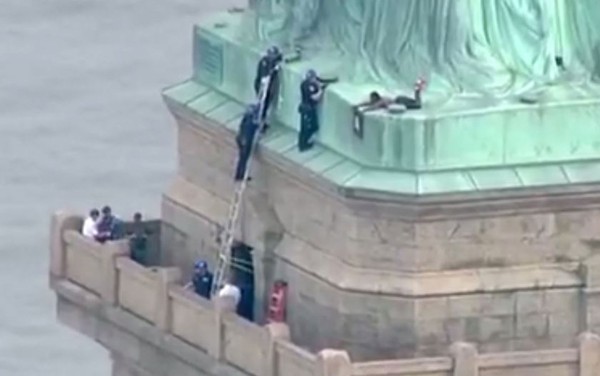 Imagem retirada de vídeo mostra policiais tentando convencer mulher a descer da base da Estátua da Liberdade