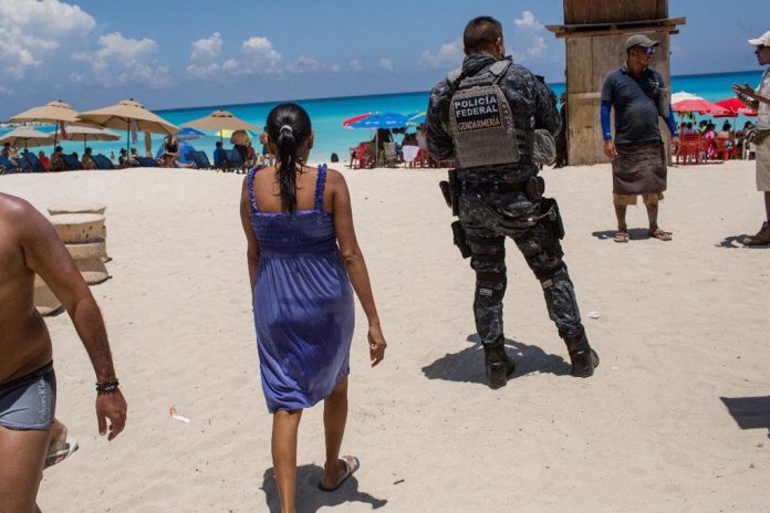 Policiais mexicanos patrulham praia em Cancún (Foto: Brett Gundlock Bloomberg)