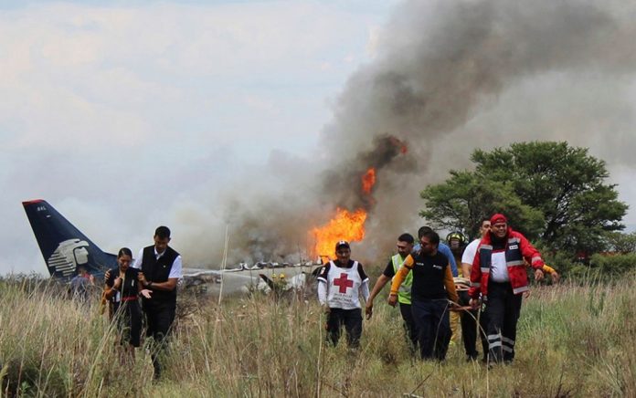 Socorristas carregam ferido em maca durante resgate após acidente com avião da Aeroméxico Foto Red Cross Durango via AP