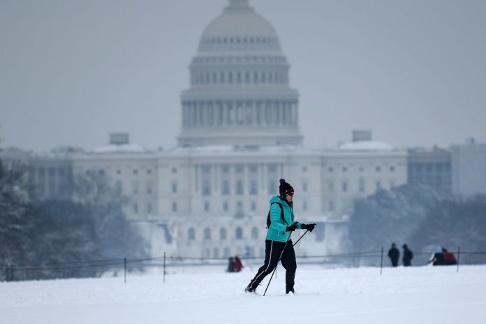 Homem esquia perto do Capitólio, em Washington, no domingo (13) — Foto Brendan Smialowski AFP