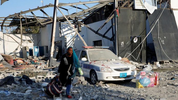 Migrante recolhe pertences no centro de refugiados de Tajura, alvo de um ataque das forças de Haftar nesta quarta-feira (3) (Foto Ismail Zitouny Reuters) Migrante recolhe pertences no centro de refugiados de Tajura, alvo de um ataque das forças de Haftar nesta quarta-feira (3) (Foto Ismail Zitouny Reuters)