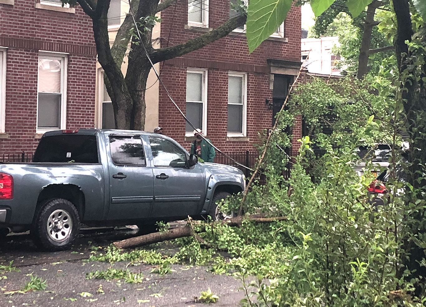 Moradores observam cabo de eletricidade caído em rua no Queens após a passagem da tempestade tropical Isaías