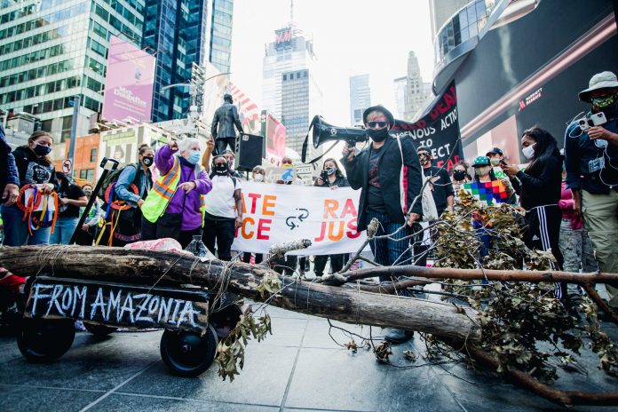 A artista plástica Adriana Varella da ANARKOARTLAB trouxe do Brooklyn até Manhattan, a pé, uma árvore queimada representando a Amazônia (foto: Tais Aquino) A artista plástica Adriana Varella da ANARKOARTLAB trouxe do Brooklyn até Manhattan, a pé, uma árvore queimada representando a Amazônia (foto: Tais Aquino)