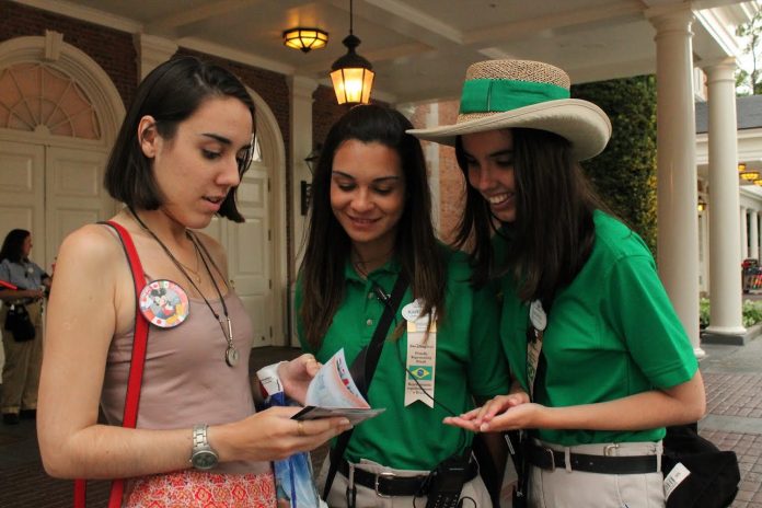 Funcionária brasileiro da Disneylândia orienta turista. Disney anunciou a demissão de 28 mil funcionários essa semana (Foto: Reprodução) Funcionário brasileiro da Disneylândia orienta turista. Disney anunciou a demissão de 28 mil funcionários essa semana (Foto: Reprodução)
