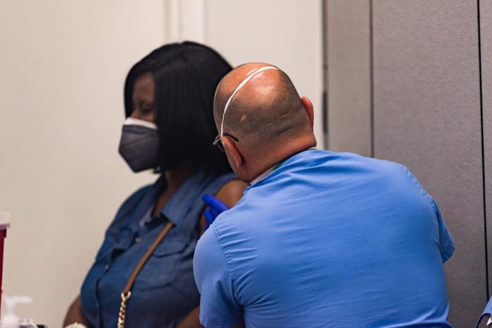 Mulher recebe vacina contra a covid-19 na igreja Impact Church em Jacksonville (foto: Facebook)