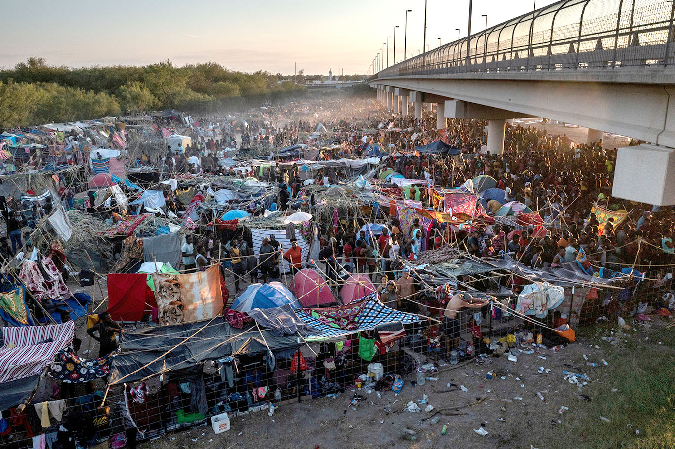 Imigrantes debaixo da Ponte Internacional Del Rio enquanto esperam para se entregar à Patrulha de Fronteira dos EUA e pedir asilo (Foto: REUTERS/Adrees Latif)
