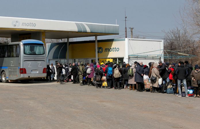Evacuados fazem fila antes de embarcar em um ônibus para deixar a cidade durante o conflito Ucrânia-Rússia no porto sul sitiado de Mariupol, Ucrânia (Foto: REUTERS/Alexander Ermochenko)