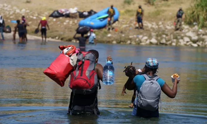Haitianos cruzando o Rio Grande na fronteira entre EUA e México (Foto: Paul Ratje/AFP)