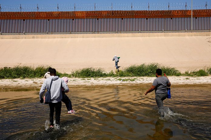Imigrantes em busca de asilo atravessam o rio Bravo para se entregar aos agentes da Patrulha de Fronteira dos EUA para solicitar asilo em El Paso, Texas (Foto: REUTERS/Jose Luis Gonzalez)