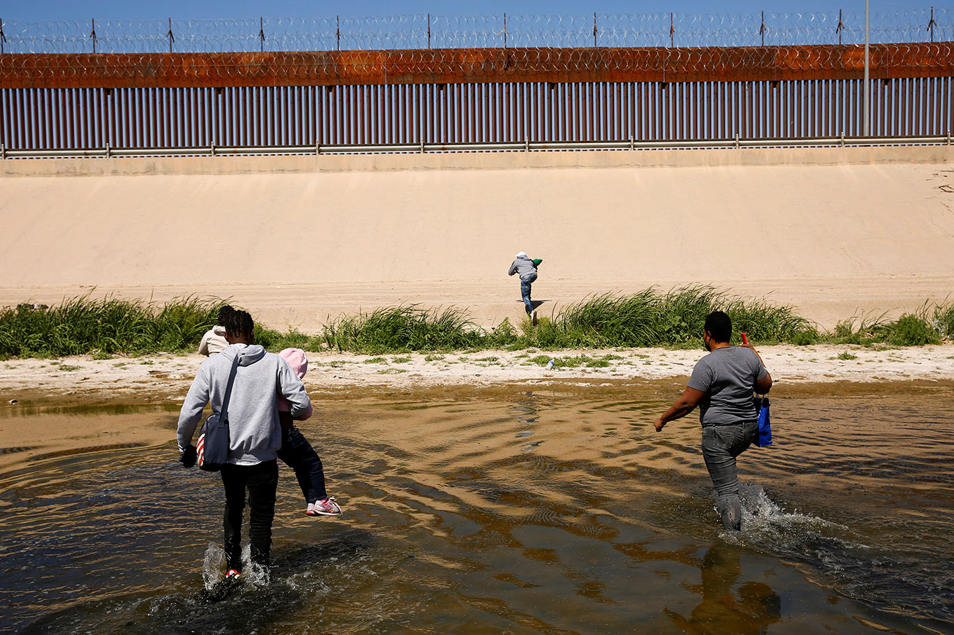 Imigrantes em busca de asilo atravessam o rio Bravo para se entregar aos agentes da Patrulha de Fronteira dos EUA para solicitar asilo em El Paso, Texas (Foto: REUTERS/Jose Luis Gonzalez)