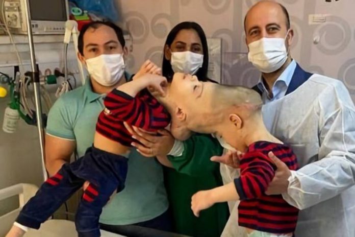 Os gêmeos Arthur e Bernardo com os pais e um dos médicos envolvidos na operação (foto: Reprodução)