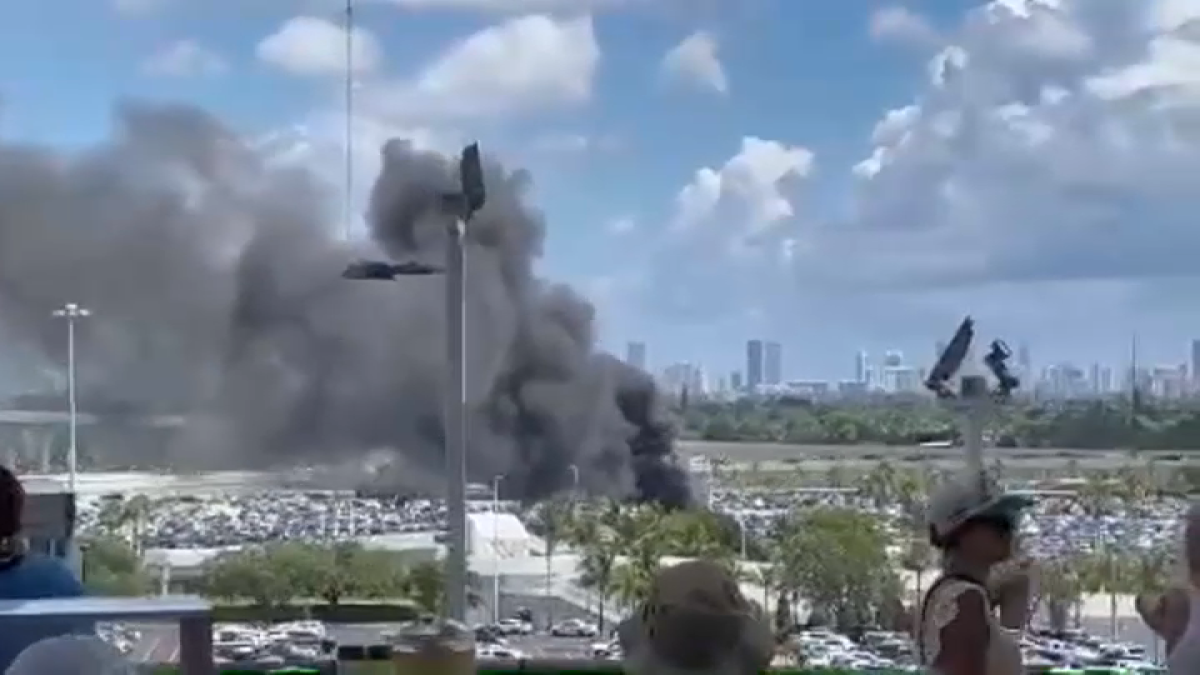 A foto mostra uma grande nuvem de fumaça preta saindo do estacionamento do lado de fora do estádio (Foto: NBC Miami
