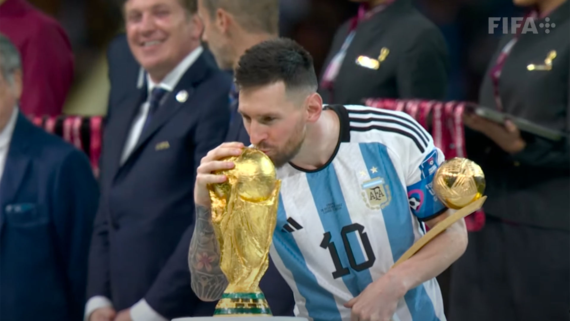 O craque Lionel Messi beija a taça segurando o troféu de craque da Copa do Mundo (Foto: Reprodução TV)
